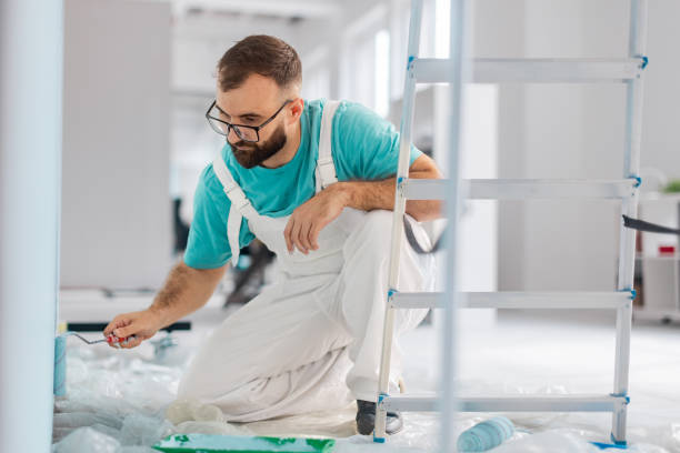 istock Painter in turquoise shirt working on apartment wall 2175664378