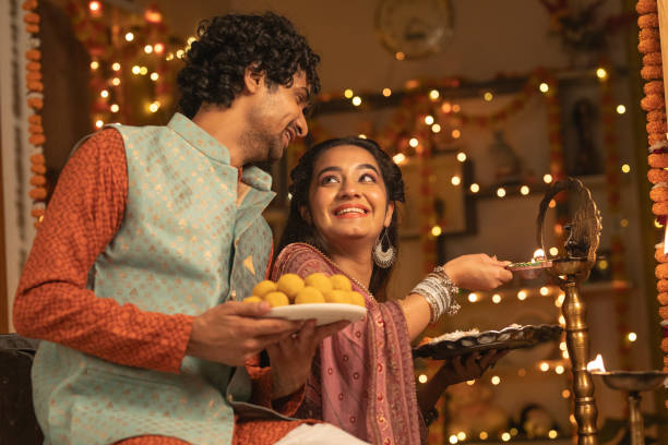 istock Young couple with diyas decorating house 2175665567
