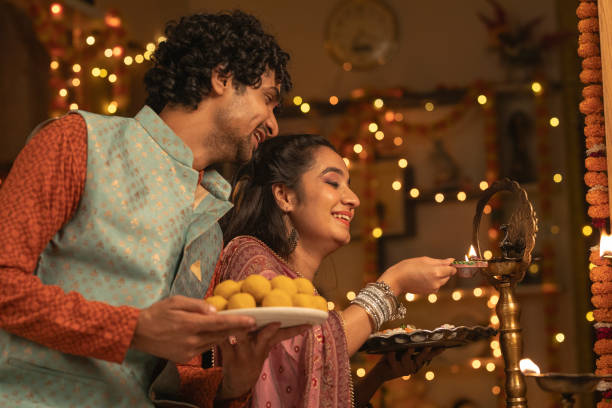 istock Young couple with diyas decorating house 2175665634