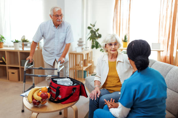 istock Female nurse talking with senior couple during home visit 2175665852