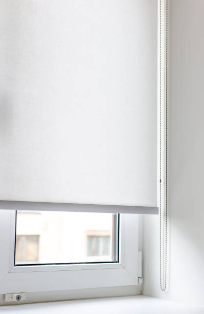 istock White roller blinds in a well-lit room with a window overlooking a cityscape 2175667901