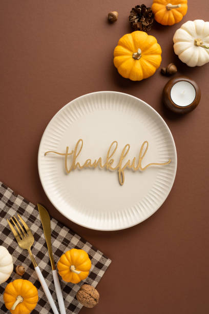 istock Festive Thanksgiving vertical table setting featuring small pumpkins, a candle, and a plate with a 'thankful' sign, capturing the seasonal mood 2175669907