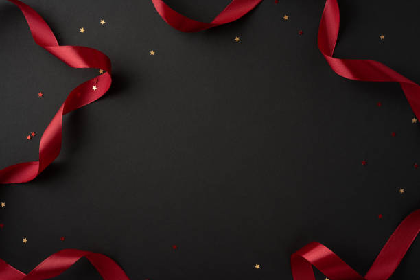 istock A stylish composition featuring a red ribbon and scattered star confetti on a smooth black background, perfect for festive occasions and celebrations 2175669914
