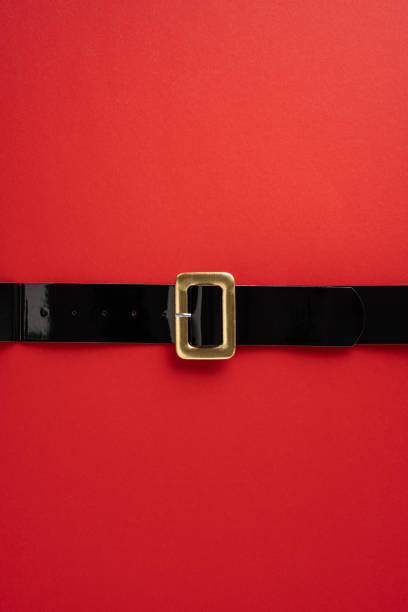 istock A classic Santa Claus belt with a gold buckle lying on a bright vertical red background, symbolizing Christmas and holiday cheer 2175669923