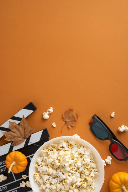 istock Cozy vertical autumn scene featuring popcorn, cinematic elements, and fall decorations. Perfect for a movie night atmosphere, combining seasonal and entertainment vibes. 2175669937