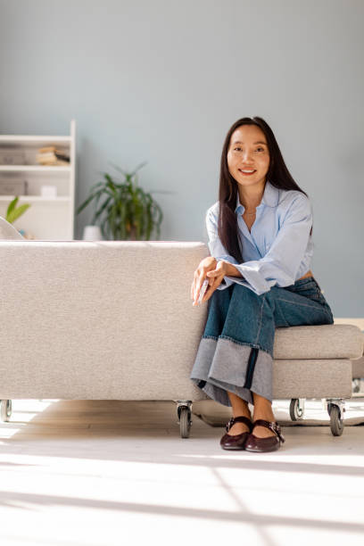 istock Woman smiling and sitting in serene styled room 2175670091