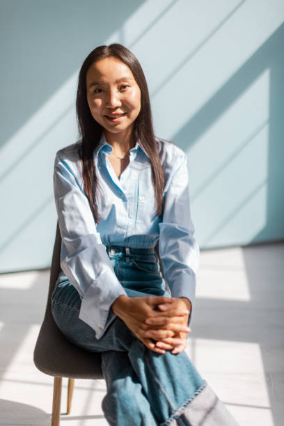 istock Young woman seated in soft sunlight with warm smile 2175674667