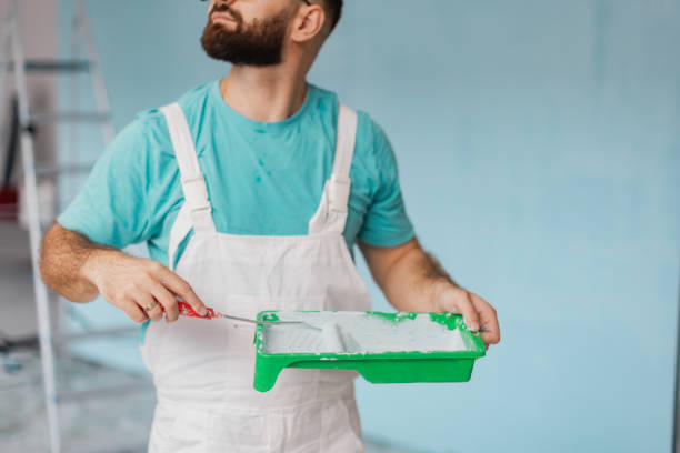 istock Painter with roller and tray prepares to apply paint. 2175676343