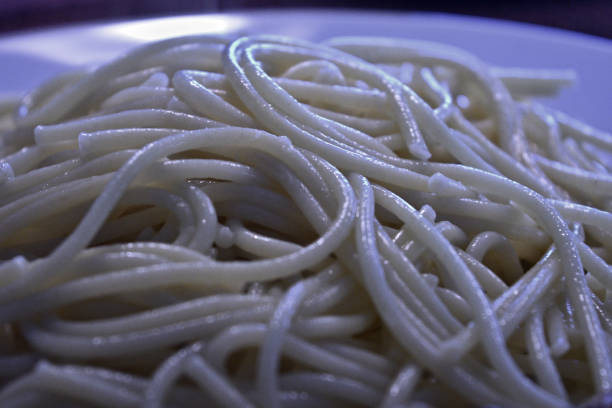spaghetti served in a clear plate on a wooden table