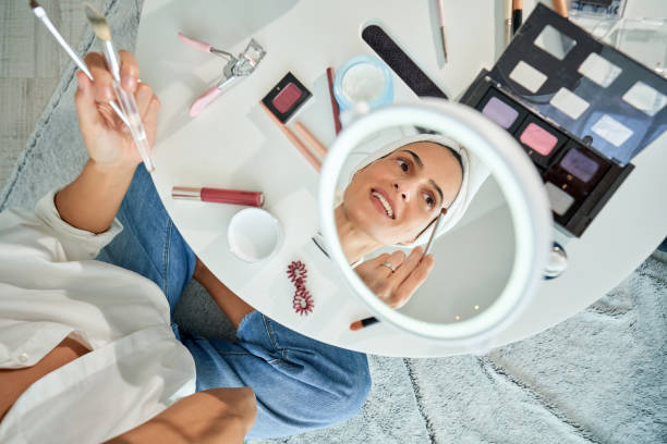 istock Woman applying eyeshadow with brush in eye makeup 2175679434