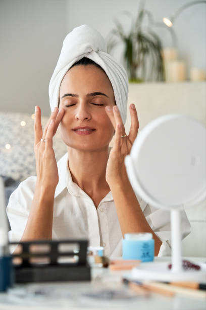 istock Delighted woman smearing anti aging cream under eyes 2175679826