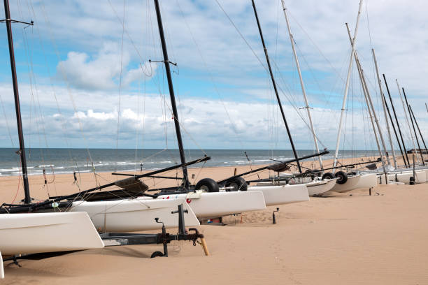 Catamaran boats on the beach in Scheveningen. North Sea in the background. Natur, sand, cloudscape, The Hague, Netherlands.
