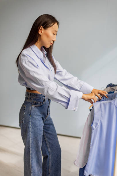 istock Woman browsing through clothes with peaceful demeanor. 2175683145