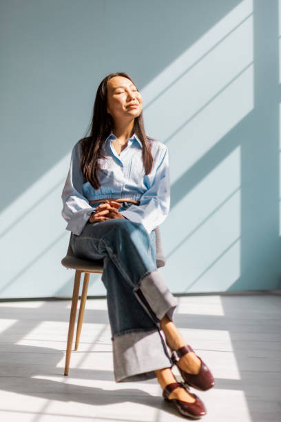 Woman enjoying sunshine sitting on chair calmly inside