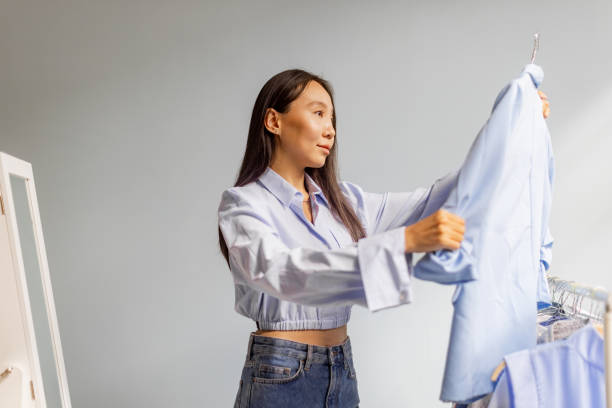 istock Woman holding up a shirt and evaluating the style. 2175685710