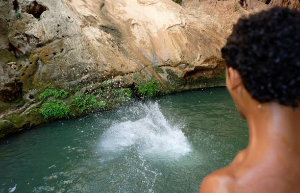 Man cliff jumping from waterfall on Cebu island during experiential trip to Philippines