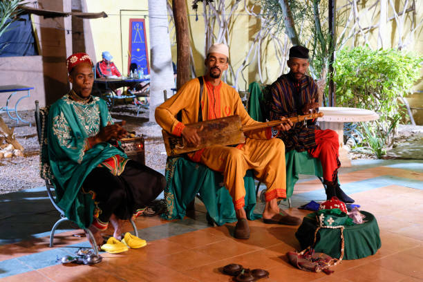 Aourir, Morocco, 08 14 2024 : group of gnawa musicians. The Gnawa or Gnaoua, Ghanawa, Ghanawi, Gnawi, are an ethnic group inhabiting Morocco, that had been brought as slaves from West African Sahel.