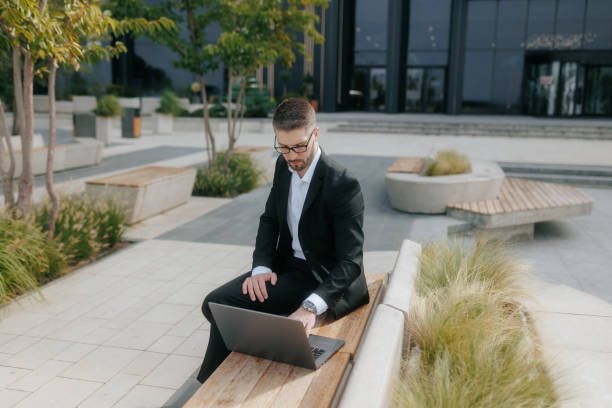istock Businessman with Glasses and Beard Concentrated on Laptop Work in a Corporate Setting 2175686483