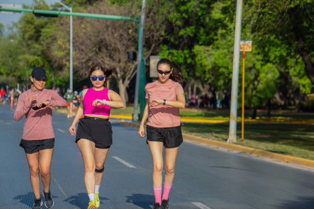 istock Three Latina women checking smartwatches while running outdoors 2175687453