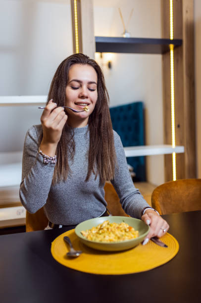 istock Woman eating mac and cheese in her apartmen. 2175688061