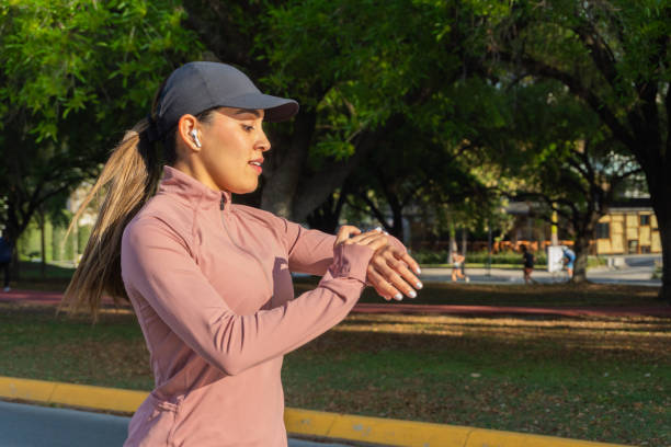 Latina woman checking smartwatch during outdoor workout