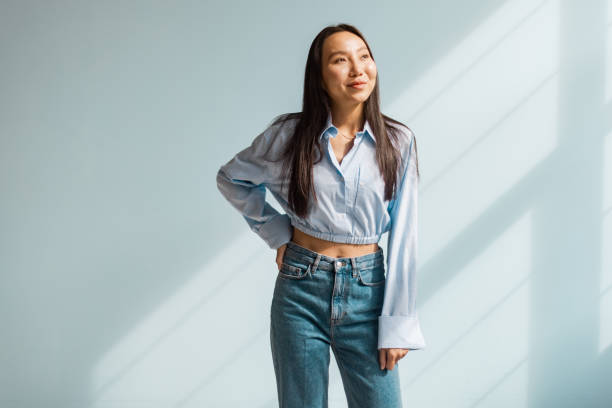 istock Casually posing woman against a backlit soft blue wall. 2175688353