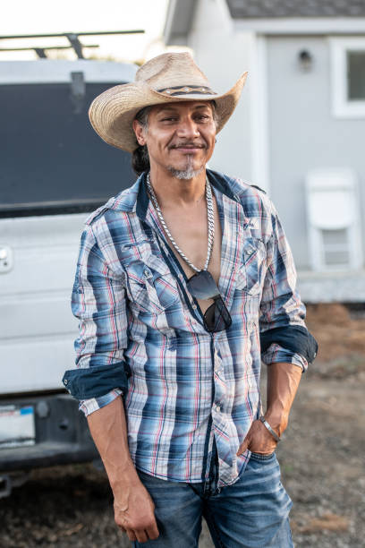istock Smiling pensive mature hispanic man looking at the camera wearing a cowboy hat 2175689348