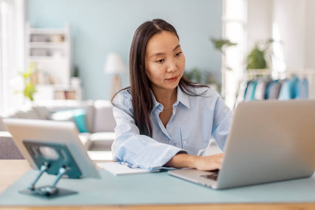 istock Confident woman typing on laptop in well-lit space. 2175689831