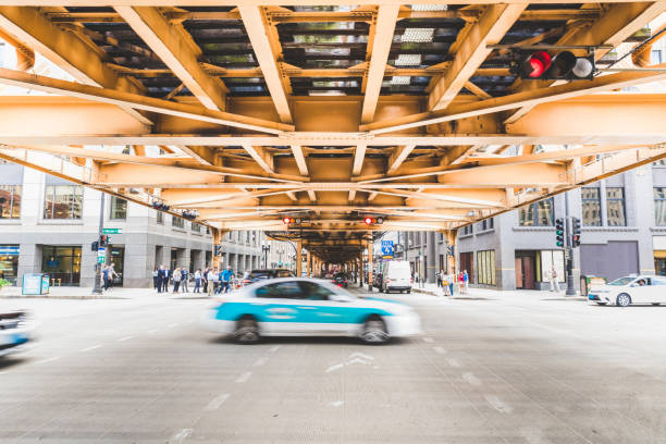 Chicago, traffic on a road passing under a bridge. Blurred cars on the road with buildings on background. American architecture and travel.