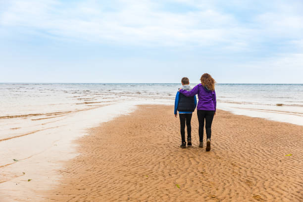 istock Boy and woman at beach on a rainy day 2175689876