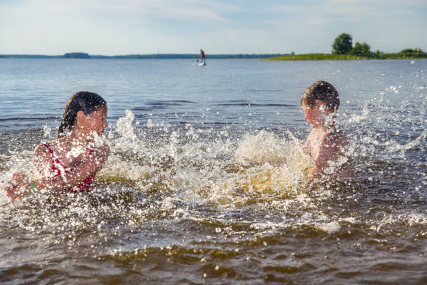 A boy and girl play in the water.  Children's summer holidays.  Splash of water.