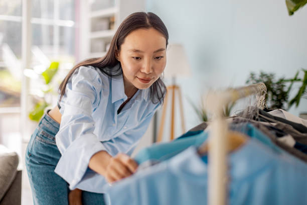 istock Focused woman examines clothes with keen attention 2175695980