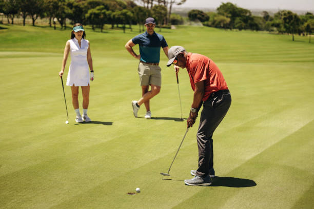 istock Golf players putting on the green as team members watch during a competitive game 2175699314