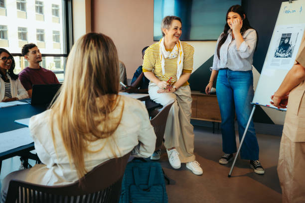 istock Informal classroom setting with a teacher engaging students through a lively discussion by the whiteboard presentation 2175700123