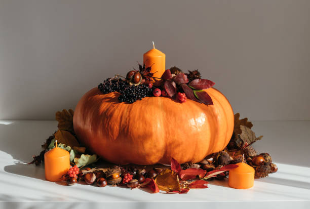 istock Beautiful autumn composition with pumpkin, candles and fall decor on a white table. Autumn festive decorations for Thanksgiving. 2175705430