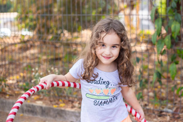 istock A girl playing with a hula hoop. 2175706384