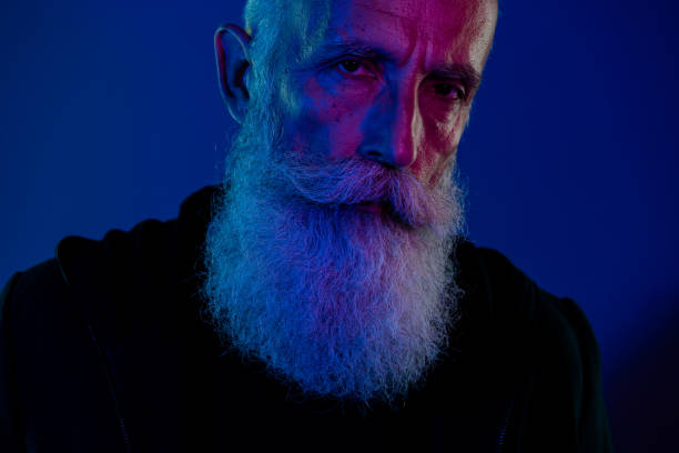 istock Photo of suspicious cool retired man dressed black pullover looking you xmas thief isolated dark blue color background 2175706504