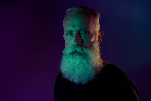 istock Photo of virile handsome retired man dressed black pullover looking you empty space isolated dark green purple color background 2175706574