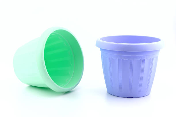 empty multi-colored plastic pots for seedlings and indoor plants and flowers, with abstract pattern, close-up, on white background, side view