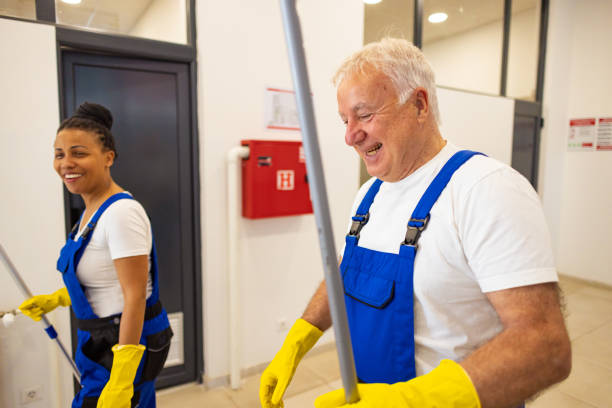istock Cheerful male and female custodians walking in school hall with working tools 2175710044