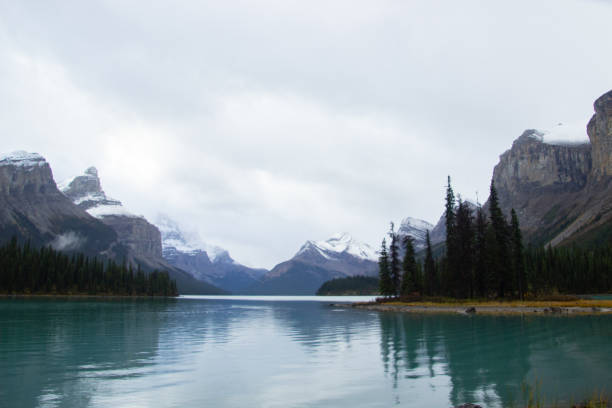 The picturesque Spirit Island is a world famous Canadian Rockies landmark on Maligne Lake, Jasper National Park, Alberta, Canada. In the background is the Hall of the Gods, with the prominent two heads of Monkhead Mountain and Mount Warren to the left of Spirit Island.