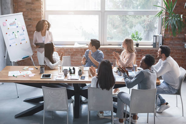 istock Black creative lady speeking in front of business team 2175710911