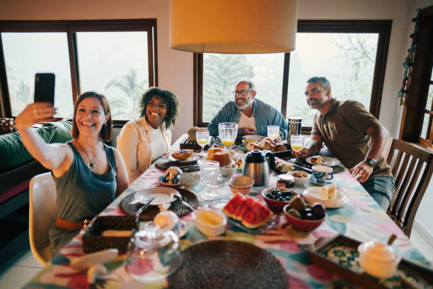 Group of friends having a breakfast together at home, in the dining table