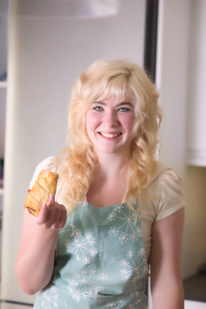 Pretty 18-year-old girl admiring the first sausage roll she's ever cooked.