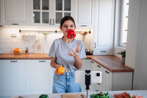 istock Girl juggles colorful peppers in modern kitchen space. 2175724261