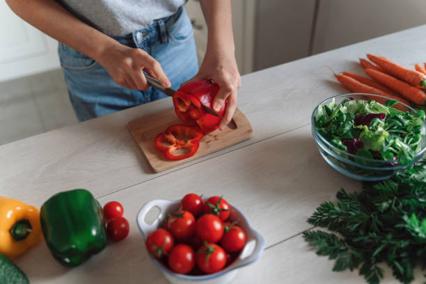 istock Hand slicing red bell pepper amidst fresh colorful veggies. 2175724271