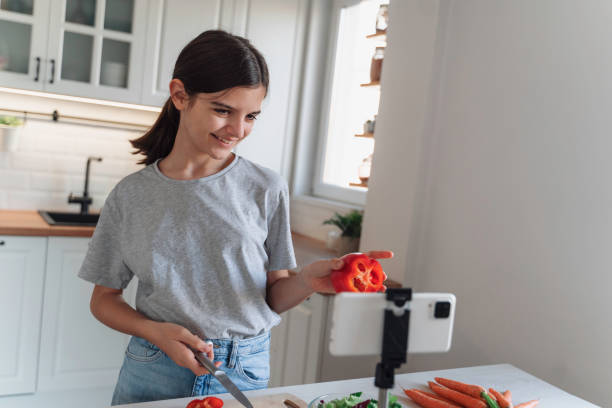 istock Girl preps vegetables for video while smiling gently. 2175724282
