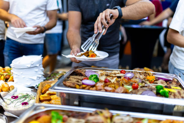 Culinary gathering at a food festival featuring diverse dishes and eager diners selecting their meals under evening lights