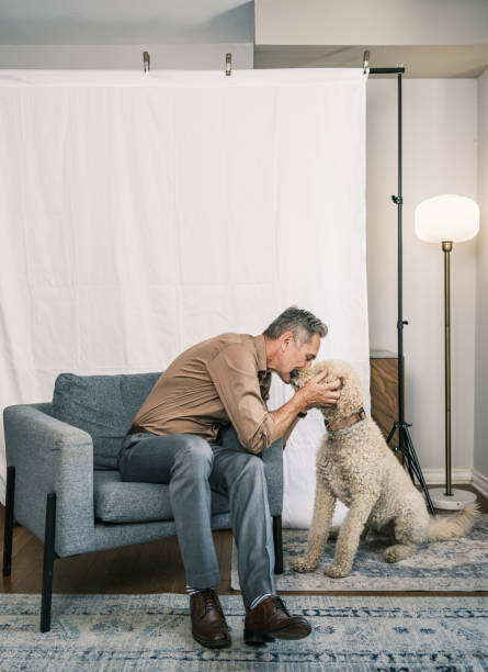 istock Mature Caucasian man and his dog posing against white backdrop 2175728949