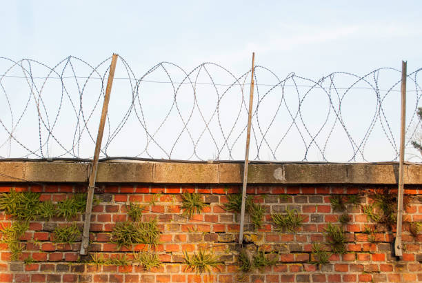 Coiled barbed wire on top of the wall. passage is strictly prohibited